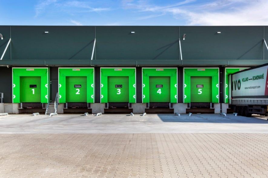 Laadperron met groene gordijnshelters en docklevellers